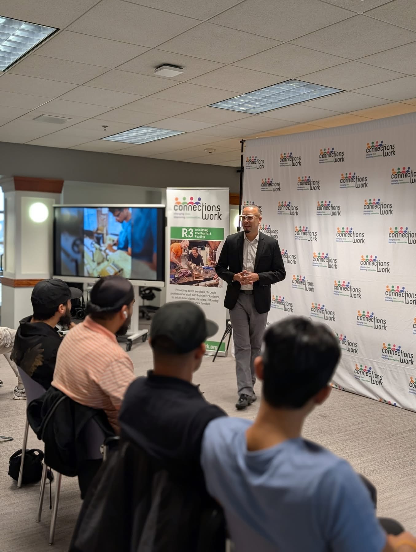 Jaime speaking to a seated audience at Connections Work