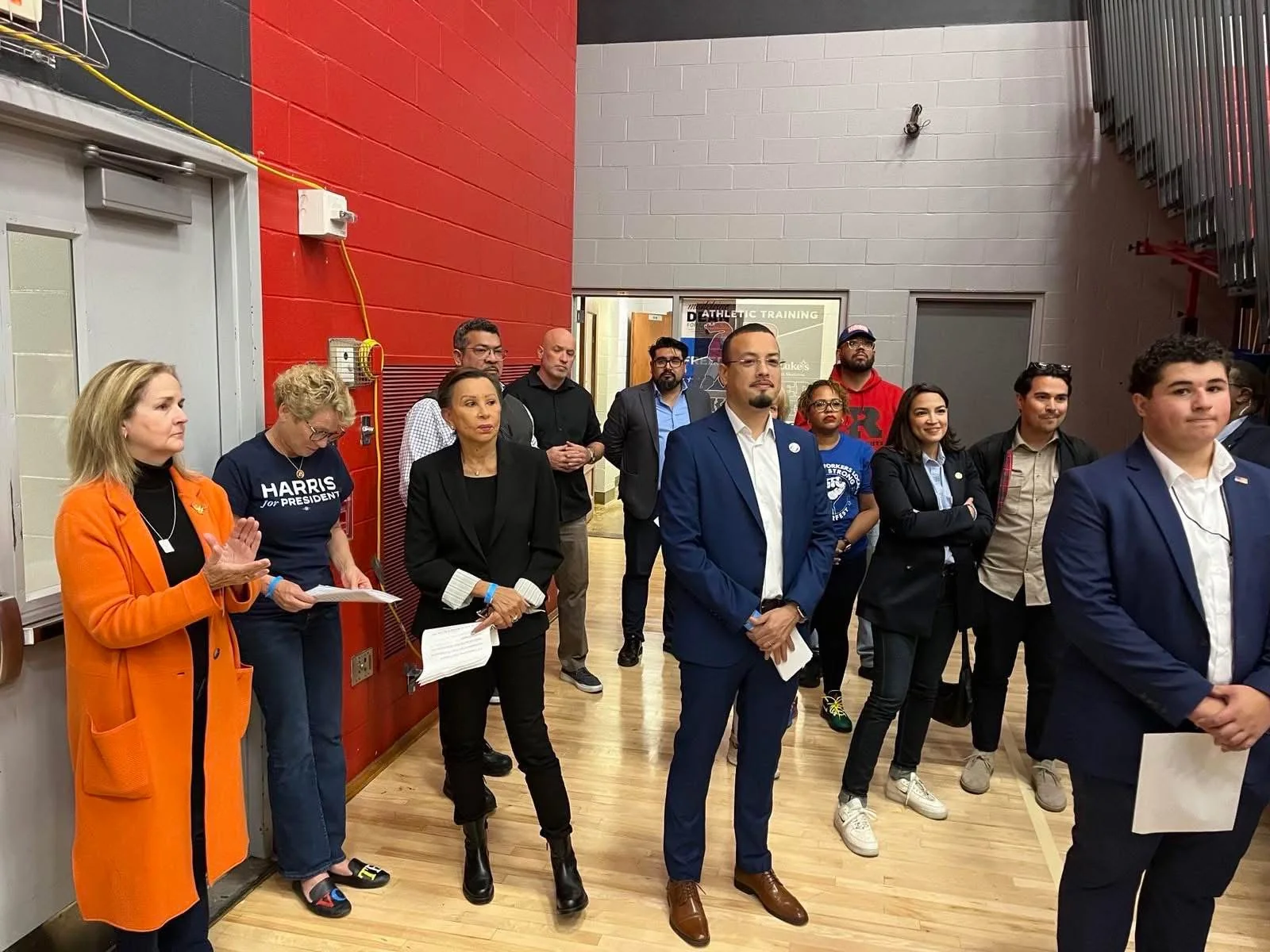 Jaime standing with a group at an indoor gathering
