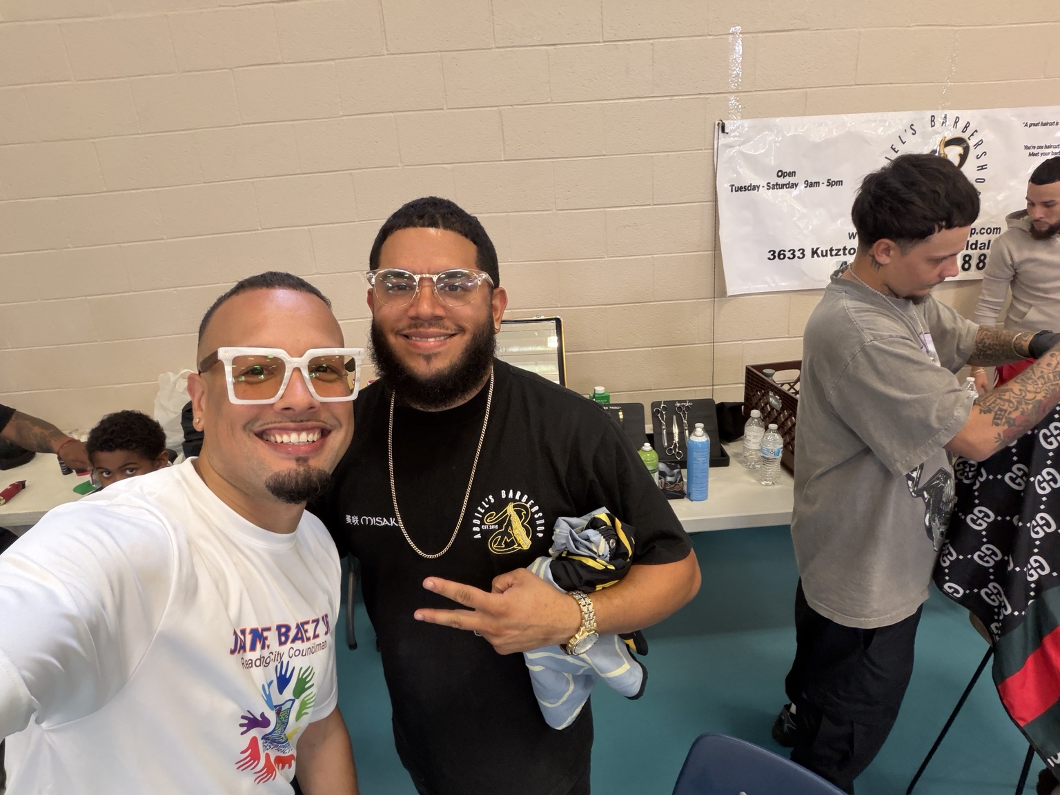Jaime with a local barber as haircuts take place at the event
